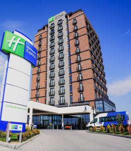 安卡拉Holiday Inn Express - Ankara - Airport, an IHG Hotel的前面有一辆公共汽车停靠的建筑