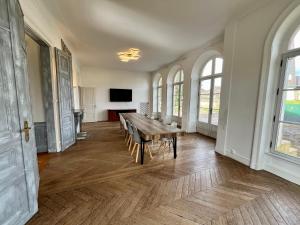 奥登河畔的布雷特维尔Superbe Maison de maître 10 chambres 300 m2 Caen的大房间设有木桌和椅子