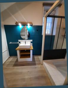 Bretteville-sur-DivesGîte de Vernelle - Saint Pierre en Auge的浴室设有白色水槽和蓝色的墙壁