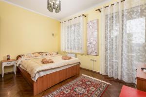 奥帕提亚Camelia & Martina apartments的一间卧室设有一张床和一个大窗户