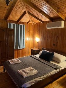 奥林波斯Olympos Çınar Hotel的木制客房内的一间卧室配有一张大床