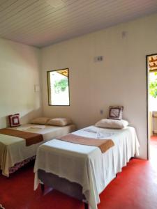库穆鲁沙蒂巴Chalé Ilha Verde-Cumuruxatiba的带2扇窗户的客房内的2张床