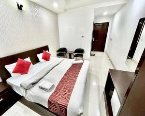 新德里Hotel Siam International的一间卧室配有一张带红色枕头的大床