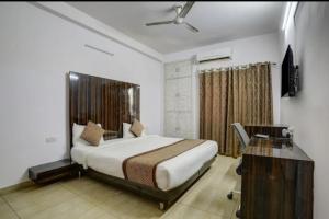 诺伊达Comfort stay Noida sector 19的一间卧室配有一张床和一张书桌