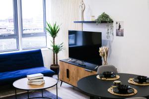 布拉克内尔Impeccable 2-Bed Luxury Apartment in Berkshire的客厅配有蓝色的沙发和电视