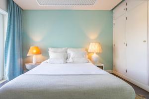 孔波尔塔Kochab Comporta的一间卧室配有一张带两盏灯的大型白色床。