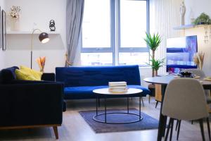 布拉克内尔Impeccable 2-Bed Luxury Apartment in Berkshire的客厅配有蓝色的沙发和桌子