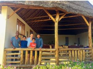 KasenyiEuphorbia Safari Lodge的站在房子前面的家庭