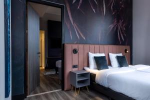 锡塔德MERICI Hotel Sittard的一间卧室配有一张带粉红色床头板的大床