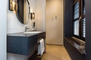 锡塔德MERICI Hotel Sittard的一间带水槽和镜子的浴室