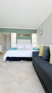 开普敦Clifton Shores的一间大卧室,配有一张床和一张沙发
