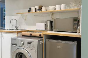 开普敦Clifton Shores的厨房配有洗衣机和微波炉。