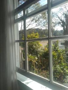 巴拉那皮亚卡巴Pousada Maranata B&B的开放式窗户,享有花园的景色