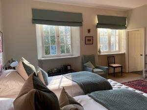 ChillinghamChillingham Manor的一间卧室设有两张床、一把椅子和窗户。