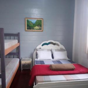 巴拉那皮亚卡巴Pousada Maranata B&B的一间卧室设有两张双层床和红色毯子
