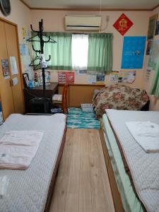 佐贺市嬉野小屋旅馆的客房设有两张床、一张桌子和一张书桌。