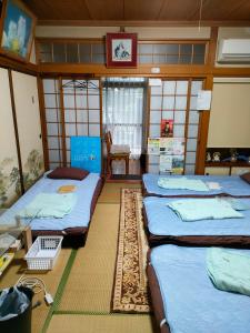佐贺市嬉野小屋旅馆的一间设有四张床和桌子的房间