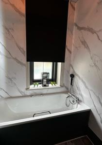 尚克林昆西米德酒店的一间带白色浴缸和窗户的浴室