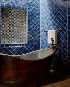 圣米格尔-德阿连德Casa de Sierra Nevada, A Belmond Hotel, San Miguel de Allende的蓝色瓷砖浴室内的旧浴缸
