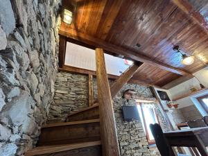 普拉利La casetta的一间设有石墙和木制天花板的客房