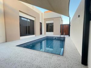 FirqAL Rabie Villa, Nizwa Grand Mall的房屋中间的游泳池