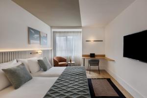 特拉维夫大都会酒店的一间酒店客房,配有一张床和一台电视
