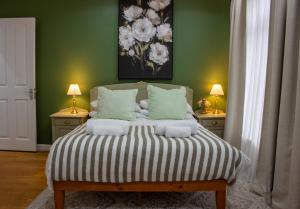 梅德斯通Elegant 4 bedroom, Maidstone house by Light Living Serviced Accommodation的一间卧室配有一张带2个床头柜的大床