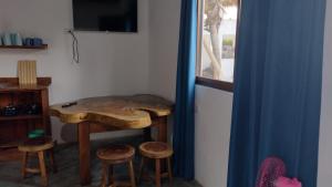 SipacateLuz del Mar Bungalos en la playa del Paredón的客房设有带凳子的木桌和窗户。