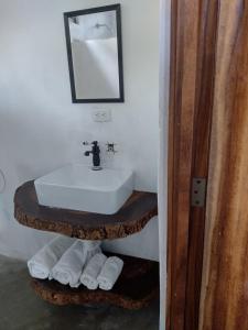 SipacateLuz del Mar Bungalos en la playa del Paredón的浴室配有盥洗盆、镜子和毛巾