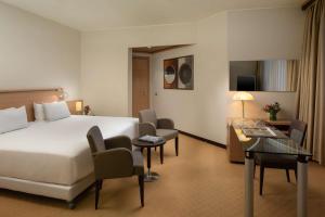维拉诺瓦博洛尼亚维拉诺瓦NH酒店的配有一张床和一张书桌的酒店客房