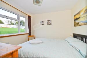 桑当117 Sandown Bay的一间卧室设有一张床和一个窗口