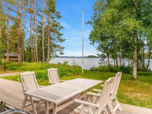 Holiday Home Villa kuorinka by Interhome的甲板上的木桌和椅子,享有水景