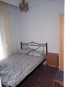 艾斯普罗瓦塔Apartment Asprovalta, Greece close to the center and the beach的一间卧室配有一张床、一盏灯和一张桌子