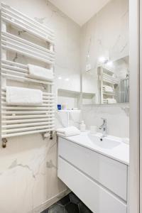皮托Appartement Puteaux la Defense的白色的浴室设有水槽和镜子