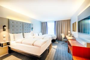 美因河畔法兰克福Premier Inn Frankfurt City Europaviertel的酒店客房配有两张床和一张书桌