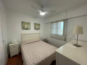 卡内拉岛Apartamento premium un dormitorio ALCAUDON的卧室配有一张床,墙上挂有两张照片