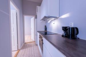 奥斯陆Maya Apartments - Sentrum的厨房设有白色的墙壁和黑色的台面
