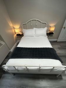 圣约翰Elegant 2-Bedroom Condo Close to Uptown的卧室配有带两盏灯的白色床