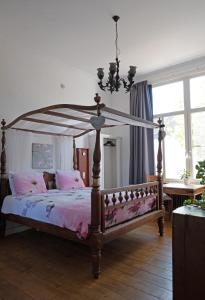 耶尔瑟克B&B Het Oude Postkantoor的一间卧室配有一张带粉红色床单的天蓬床