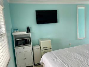 迈尔斯堡海滩弗拉明戈汽车旅馆的卧室配有一张床,墙上设有微波炉