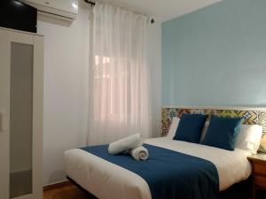 科尔多瓦PENSION CIBELES的一间卧室配有两张带蓝色枕头的床