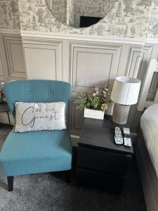 新港韦弗利宾馆的一间卧室配有蓝色椅子和一张带枕头的桌子