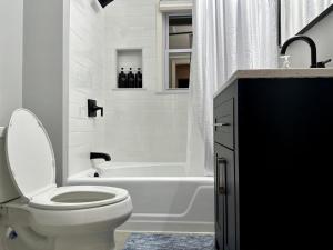 波士顿Harvrd-MIT-B.U./Parkfree/Single Family residence的白色的浴室设有卫生间和浴缸。