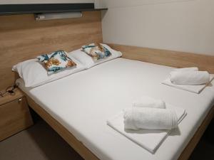 皮罗瓦茨CHARTA mobile home Maya的一张带两个枕头的大白色床