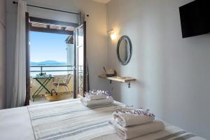 巴尔巴蒂Hotel Barbati Sea View B&B的一间卧室配有带毛巾的床和阳台