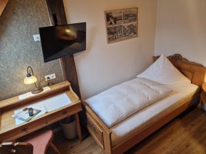 海利根堡霍斯贝恩旅馆的一间小卧室,配有一张床和一张书桌