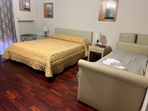 波蒂奇Gioviale Rooms的一间卧室配有一张床、一张沙发、一张床和一把椅子