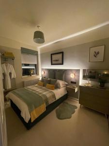 霍尔Cosy Room In Altrincham的一间卧室设有一张大床和一个窗户。