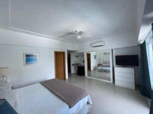 璜多里奥Elegante Blue Marine Apartamento Juan Dolio的白色卧室配有床和平面电视