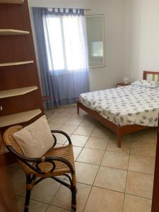 丽都玛里尼SPELU - Appartamento con terrazza fronte mare的卧室配有床、椅子和窗户。